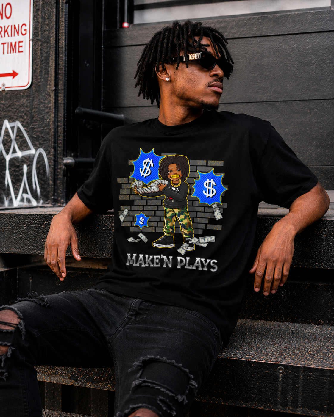 Man wearing a black t-shirt with graphic design and text, sitting on steps.